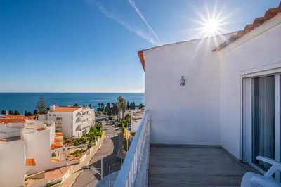 a balcony of a white building with a view of the ocean at Apartment Atlas in Albufeira