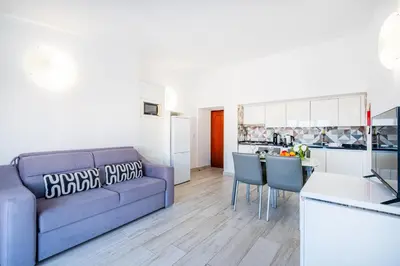 a living room with a blue couch and a kitchen at Apartment Atlas in Albufeira
