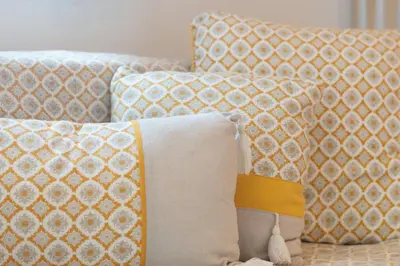 a couch with pillows and a blanket on it at Charming Yellow Studio in Albufeira in Olhos de Água