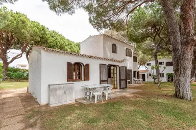 a white house with a table in the yard at Charming Yellow Studio in Albufeira in Olhos de Água