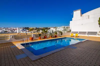 a dining room with a table and a large window at Downtown Apartment - By D`alma Portuguesa in Albufeira