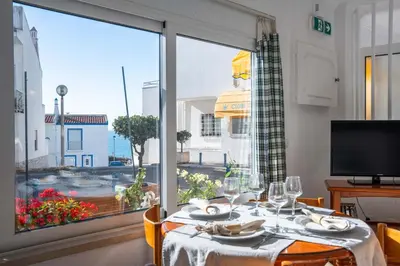 a dining room and living room with a table and chairs at Downtown Apartment - By D`alma Portuguesa in Albufeira