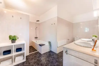 a white bathroom with a sink and a tub and a bath tub at Casa Federica by Algarve Holidays in Santa Bárbara de Nexe