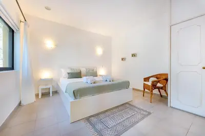 a bedroom with a bed in a white room at Casa Federica by Algarve Holidays in Santa Bárbara de Nexe