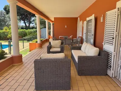 a patio with wicker furniture and a table and chairs at Palm Villa in Albufeira