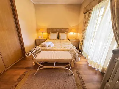 a bedroom with a bed and a large window at Palm Villa in Albufeira