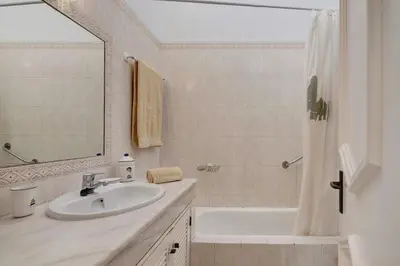 a white bathroom with a sink and a shower at Sail Golf Vilamoura V3 in Quarteira