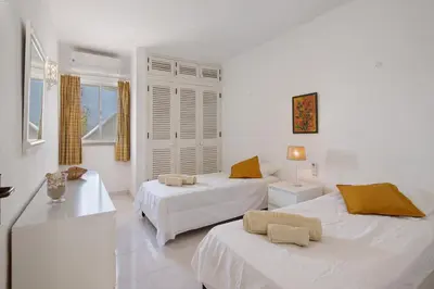 a white room with two beds and a table at Sail Golf Vilamoura V3 in Quarteira