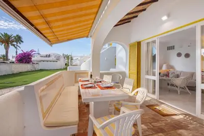 a dining room with a table and chairs on a patio at Sail Golf Vilamoura V3 in Quarteira