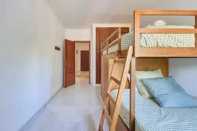 a room with two bunk beds and a hallway at 2 Bedroom by Quarteira Beach in Quarteira