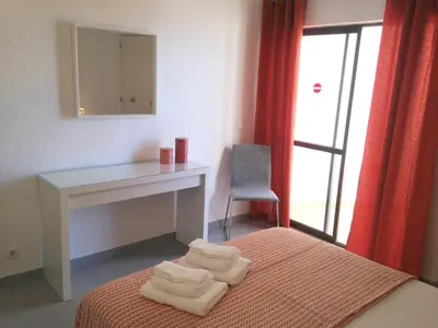 a bedroom with a desk and towels on a bed at Casa Vila Magna in Albufeira