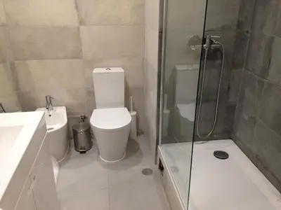 a bathroom with a toilet and a glass shower at Casa Vila Magna in Albufeira