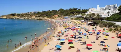a crowd of people on a beach with umbrellas at Casa Vila Magna in Albufeira