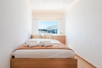 a street in front of a building next to the ocean at Sandora Pearl By Seareen, Penthouse with sea view in Albufeira