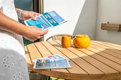 a woman holding a book next to a table at Downtown Luxury Studio - Faro in Faro