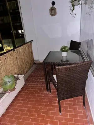 a patio with a table and chairs and a laptop at Vilamoura Living 106 in Quarteira