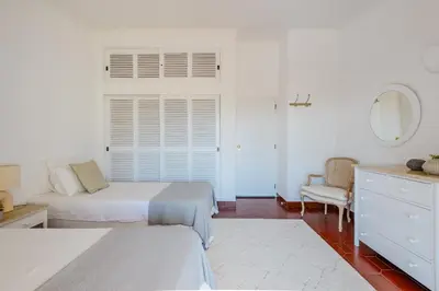 a white bedroom with two beds and a window at Vale do Lobo Apartment D in Vale do Lobo