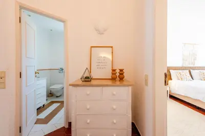 a bedroom with a dresser and a bed and a bathroom at Vale do Lobo Apartment D in Vale do Lobo