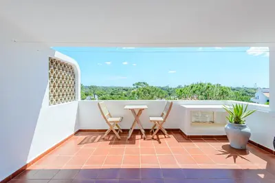 a balcony with a table and chairs on it at Vale do Lobo Apartment D in Vale do Lobo