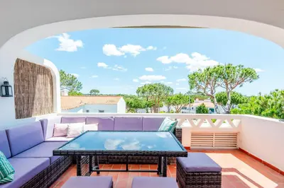 a patio with a purple couch and a table at Vale do Lobo Apartment D in Vale do Lobo