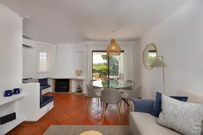 a living room with a couch and a table and chairs at Albufeira Club 109 in Albufeira