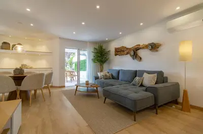 a living room with a couch and a table at Luxury Garden House Apartment - Golf & Tennis Court & Pools in Albufeira