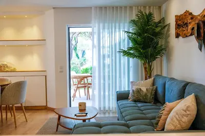 a living room with a blue couch and a table at Luxury Garden House Apartment - Golf & Tennis Court & Pools in Albufeira