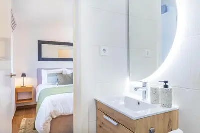 a bathroom with a white sink and two mirrors at Casa Milea - Vilamoura Marina in Vilamoura