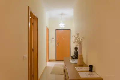 a hallway with a table and a door with a vase at Apartament Encosta Da Orada in Albufeira