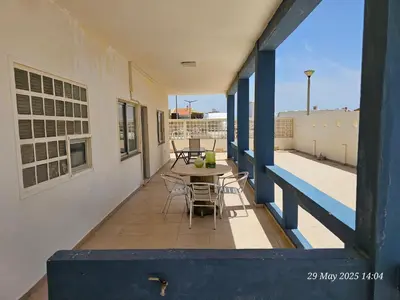 a balcony with tables and chairs on a building at Blife Bandaya private rooms at Faro beach in Faro