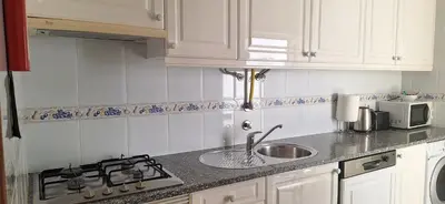 a kitchen counter with a sink and a stove at Manu's Place in Albufeira