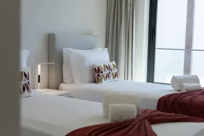a hotel room with two beds and a window at Terracos de Quarteira II Pearl by Real Properties in Quarteira