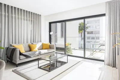 a living room with a couch and a glass table at Terraccos de Quarteira Silver by Real Properies in Quarteira