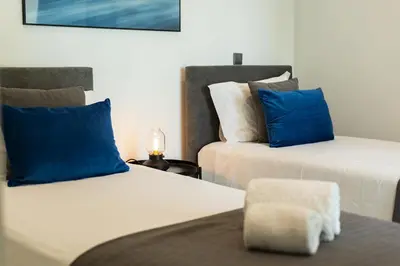 two beds with blue and white pillows in a room at Terraccos de Quarteira Silver by Real Properies in Quarteira