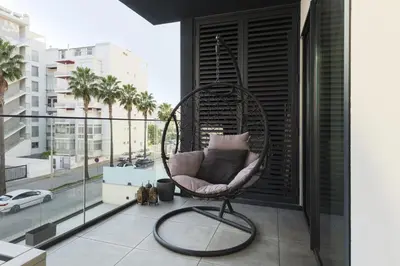 a chair on a balcony with a view of a city at Terraccos de Quarteira Silver by Real Properies in Quarteira
