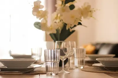 a table with glasses and a vase of flowers at Alta Oura 2 in Albufeira