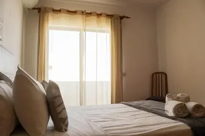 a bedroom with a bed with a large window at Alta Oura 2 in Albufeira