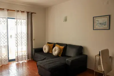 a living room with a black couch with pillows at Alta Oura 2 in Albufeira