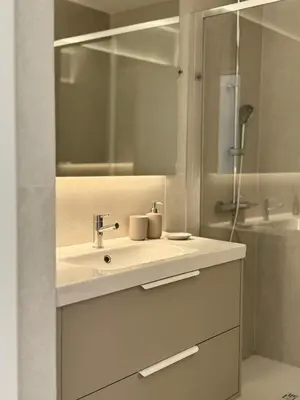 a white bathroom with a sink and a shower at Casa do Largo - Quarteira Algarve in Quarteira