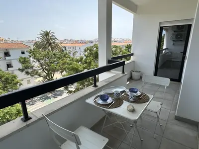 a room with a balcony with a table and chairs at Âncora Mar by FHR in Quarteira