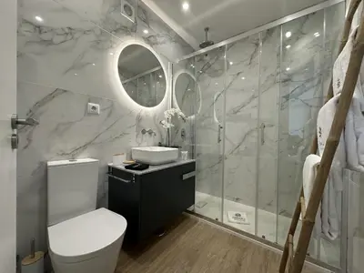 a bathroom with a toilet and a sink and a shower at Âncora Mar by FHR in Quarteira