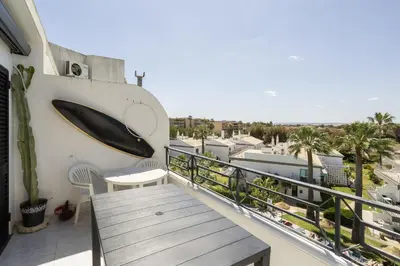 a balcony with a table and a surfboard on the wall at Albufeira Salgados Sailor House in Galé