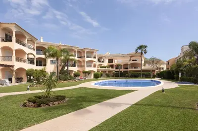 a large apartment complex with a swimming pool in the yard at Praia Village III - Peaceful condominium by HD in Quarteira