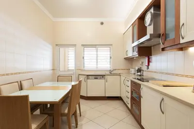a kitchen with a table and a dining room at Praia Village III - Peaceful condominium by HD in Quarteira