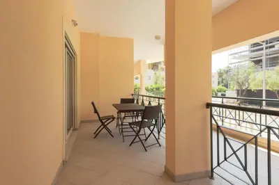 a balcony with chairs and a table in a building at Praia Village III - Peaceful condominium by HD in Quarteira