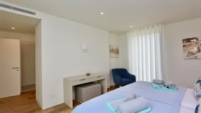 a bedroom with two beds and a blue chair at Villa Rimah, Sunny Algarve, Entire Home 