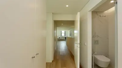 a white bathroom with a toilet and a hallway at Villa Rimah, Sunny Algarve, Entire Home 