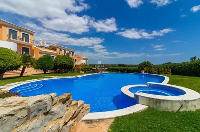 a swimming pool in a yard next to a house at Rosemary Apartment in Olhos de Água