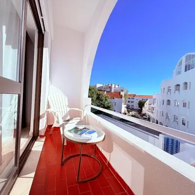 a white bedroom with a bed and two night stands at Casita 9 in Albufeira