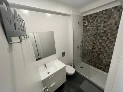 a bathroom with a sink and a toilet and a shower at Train Station Guesthouse in Faro